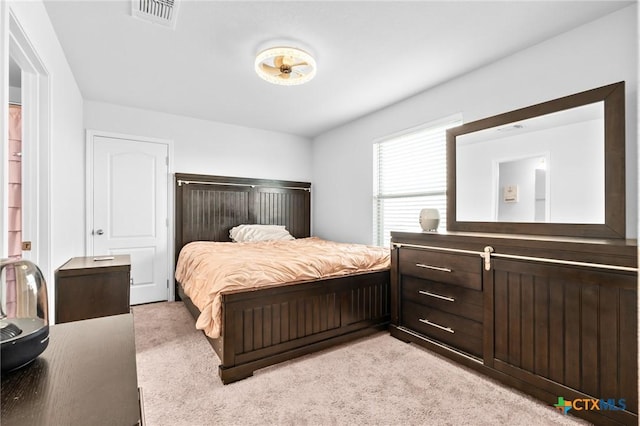 bedroom with visible vents and light colored carpet