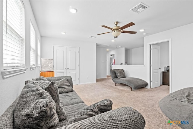 living room featuring a wealth of natural light, visible vents, and carpet floors