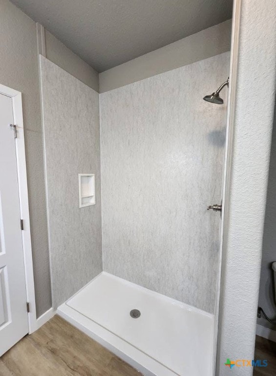 full bathroom with wood finished floors and a stall shower