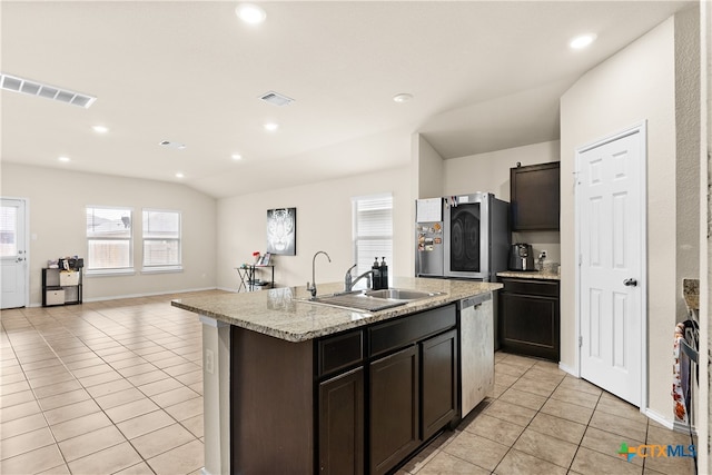 kitchen featuring light tile patterned flooring, lofted ceiling, sink, and a center island with sink