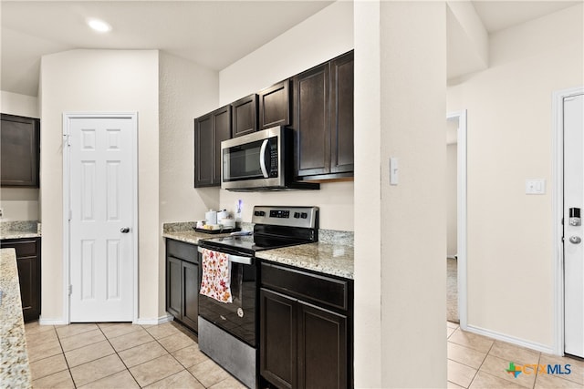 kitchen featuring dark brown cabinets, light tile patterned floors, light stone counters, and appliances with stainless steel finishes