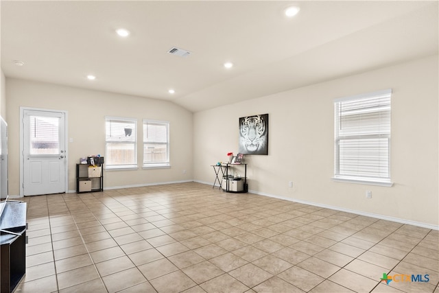 unfurnished living room with light tile patterned floors and vaulted ceiling