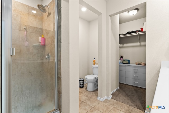 bathroom with tile patterned floors, toilet, and an enclosed shower