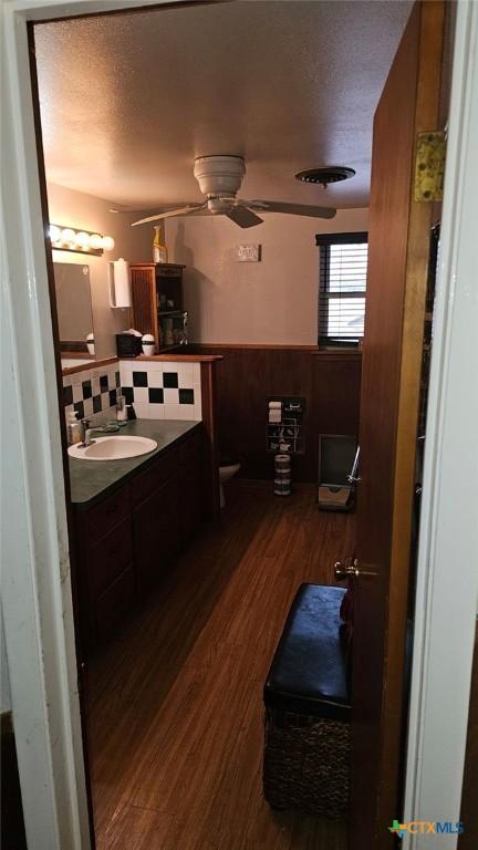 bathroom with vanity, hardwood / wood-style floors, a textured ceiling, and ceiling fan