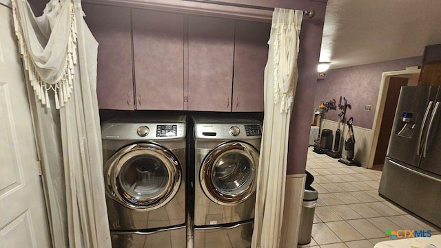 clothes washing area featuring light tile patterned floors and washer and clothes dryer