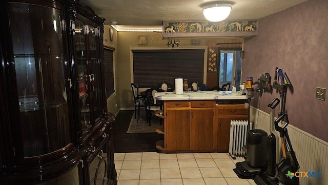 kitchen with radiator heating unit, tile countertops, and light tile patterned floors