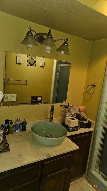 bathroom featuring a shower with door, vanity, and tile patterned floors