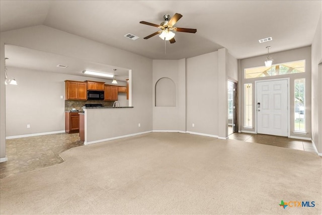 unfurnished living room featuring carpet, visible vents, ceiling fan, and baseboards