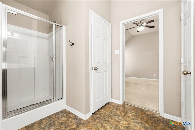 bathroom with a stall shower and baseboards