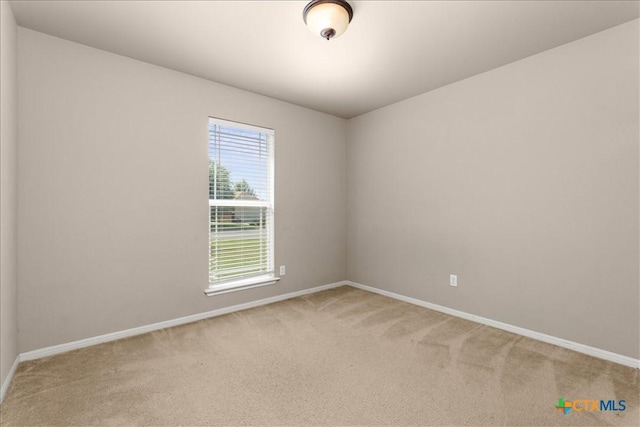 carpeted empty room featuring baseboards