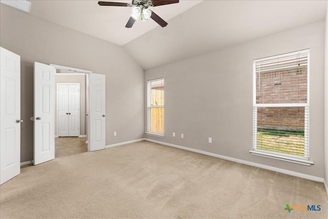 unfurnished bedroom with lofted ceiling, light carpet, ceiling fan, and baseboards