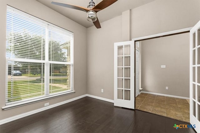 unfurnished bedroom with dark wood-type flooring, french doors, baseboards, and a ceiling fan