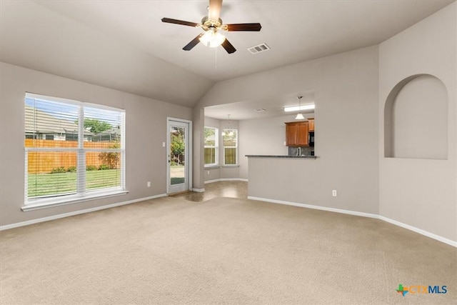 unfurnished living room with ceiling fan, light colored carpet, visible vents, and baseboards