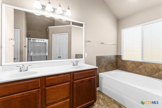 full bathroom with a bath, a stall shower, double vanity, and a sink