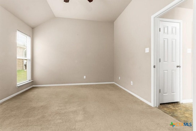 empty room with lofted ceiling, baseboards, a ceiling fan, and light colored carpet