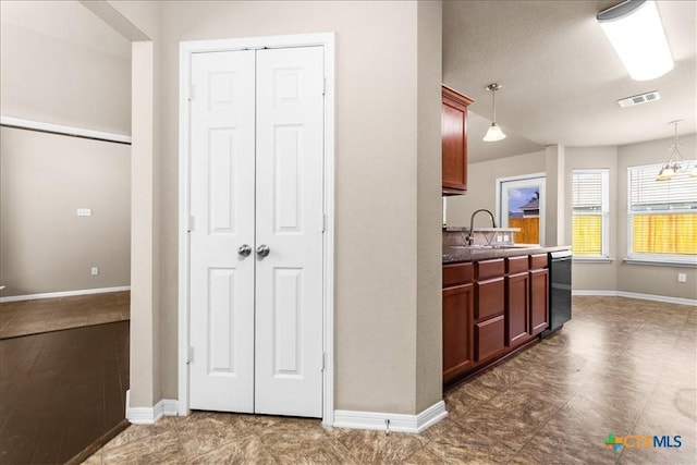 kitchen with dishwasher, visible vents, pendant lighting, and a sink