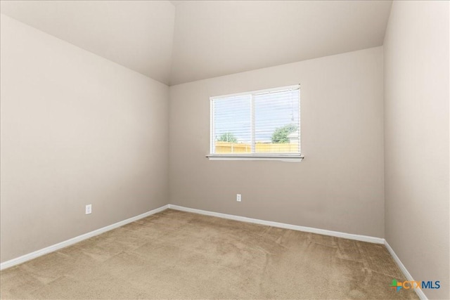 empty room featuring light colored carpet and baseboards