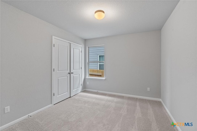 carpeted spare room featuring a textured ceiling