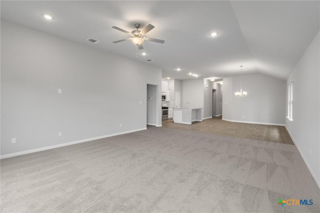 unfurnished living room featuring light colored carpet, lofted ceiling, sink, and ceiling fan with notable chandelier