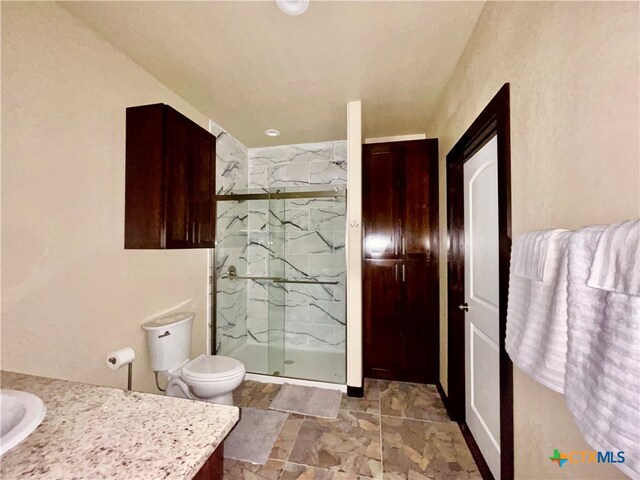 bathroom featuring vanity, toilet, and an enclosed shower