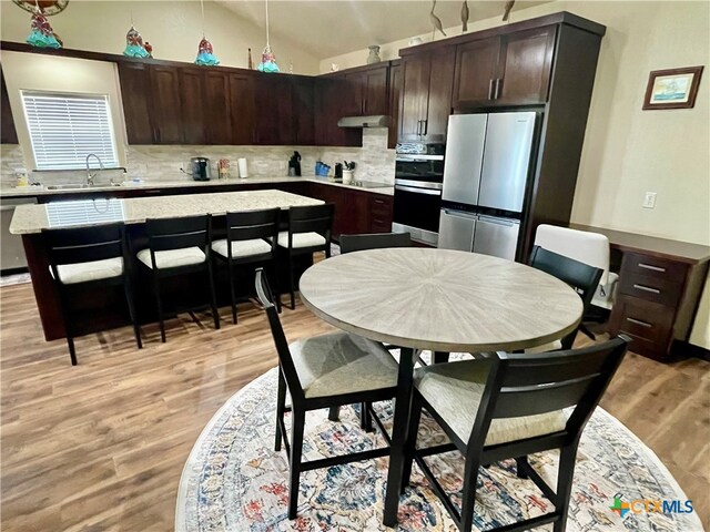 kitchen with light hardwood / wood-style flooring, dark brown cabinetry, and stainless steel appliances