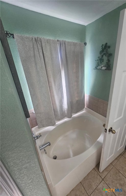 bathroom featuring tile patterned flooring and a tub to relax in