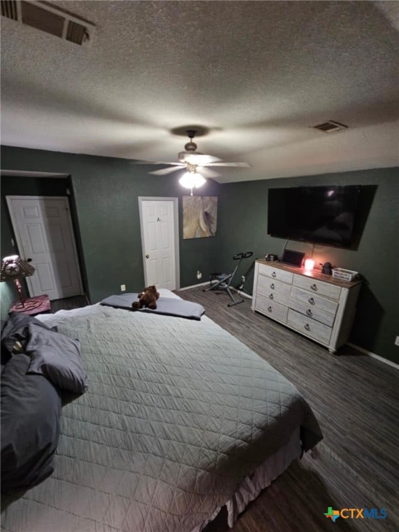 bedroom featuring ceiling fan, wood-type flooring, and a textured ceiling