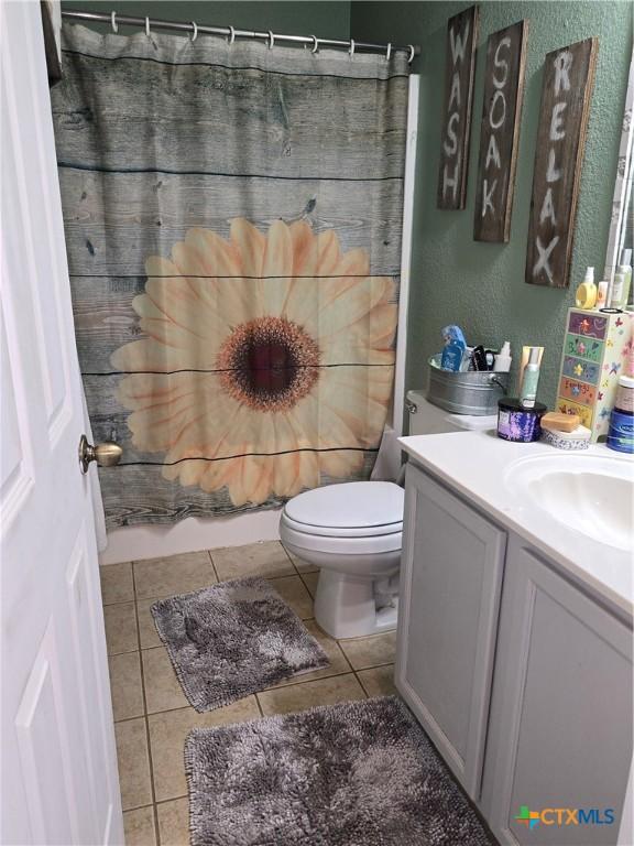 2301 Jake Dr, Copperas Cove, TX 76522 - bathroom featuring toilet, vanity, tile patterned flooring, and a textured wall