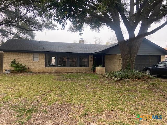 ranch-style home featuring a garage and a front yard