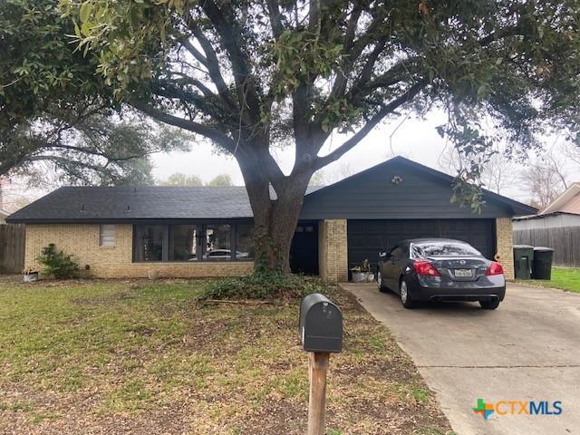 ranch-style home with a garage and a front lawn