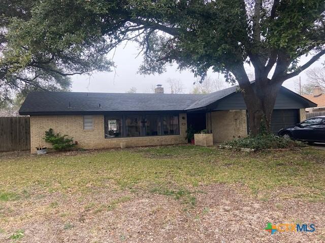 ranch-style house featuring a garage and a front lawn