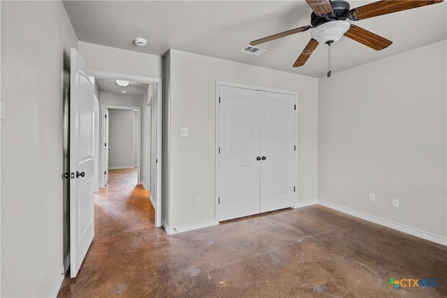 unfurnished bedroom with finished concrete flooring, baseboards, visible vents, and a closet