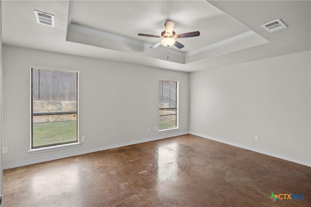 spare room featuring a raised ceiling, visible vents, finished concrete flooring, and baseboards