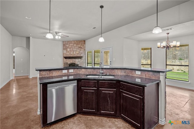 kitchen with concrete flooring, a stone fireplace, a sink, open floor plan, and dishwasher