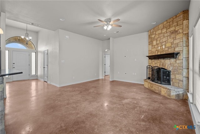 unfurnished living room with ceiling fan with notable chandelier, concrete floors, a fireplace, visible vents, and baseboards