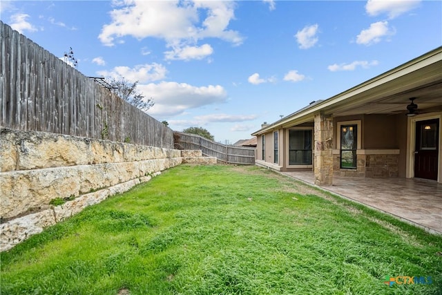 view of yard with a patio area, a fenced backyard, and ceiling fan