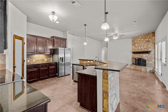 kitchen featuring finished concrete flooring, visible vents, backsplash, appliances with stainless steel finishes, and a sink