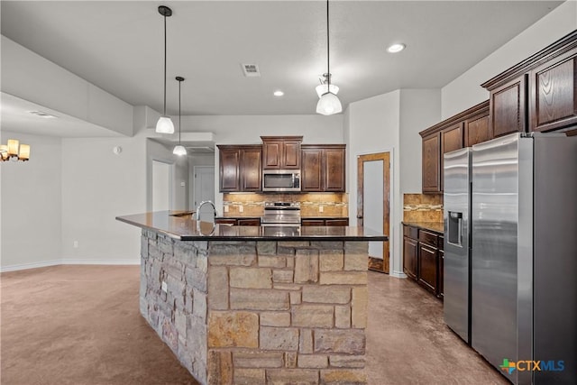 kitchen featuring visible vents, dark brown cabinets, appliances with stainless steel finishes, a large island, and tasteful backsplash