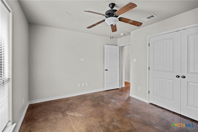 unfurnished bedroom with concrete flooring, a closet, visible vents, and baseboards