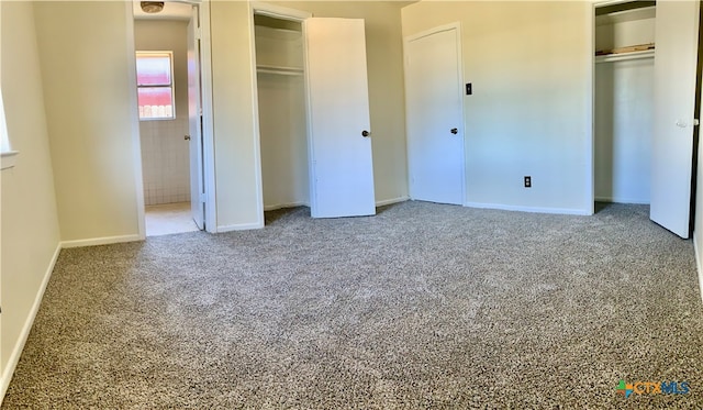 unfurnished bedroom with carpet flooring and multiple closets