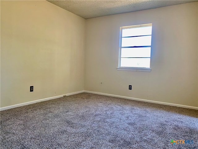 carpeted empty room with a textured ceiling