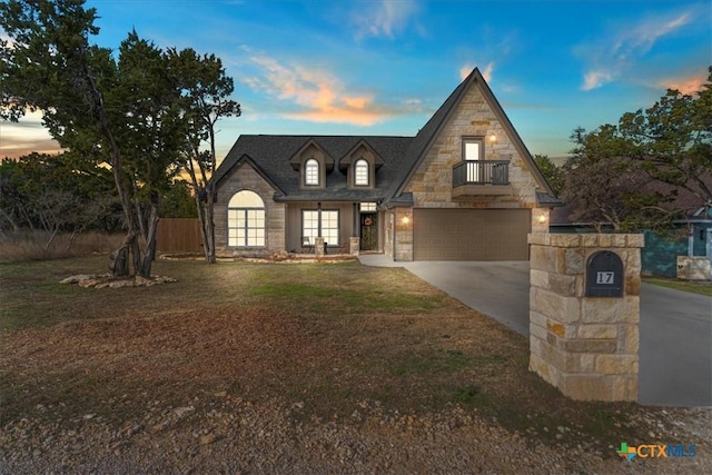 view of front of house with a lawn, a balcony, and a garage