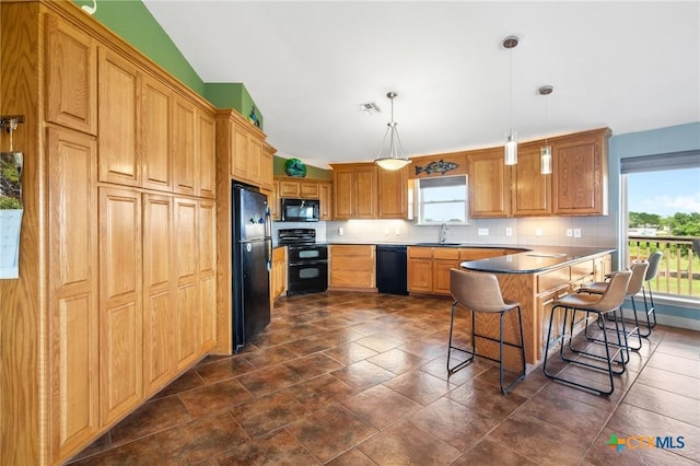 kitchen featuring pendant lighting, backsplash, a kitchen breakfast bar, black appliances, and vaulted ceiling