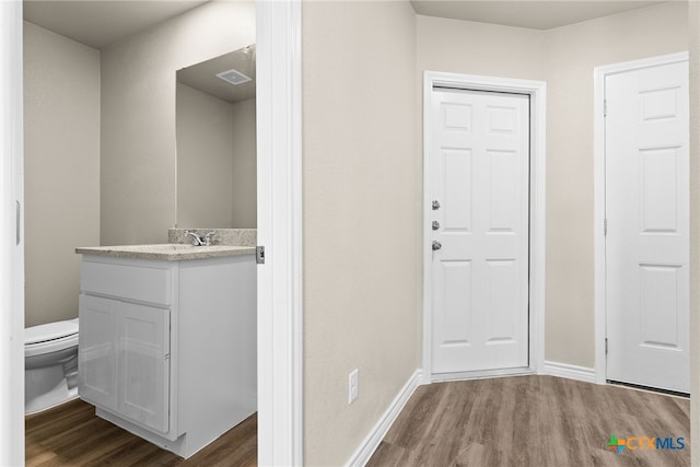 interior space featuring hardwood / wood-style floors, vanity, and toilet