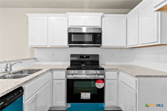 kitchen featuring white cabinets, decorative backsplash, appliances with stainless steel finishes, and sink