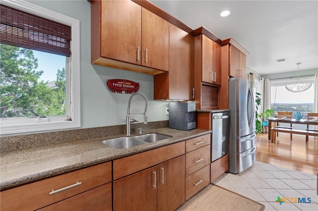 18917 Peckham Dr, Lago Vista, TX 78645 - kitchen featuring stainless steel appliances, healthy amount of natural light, brown cabinetry, and recessed lighting