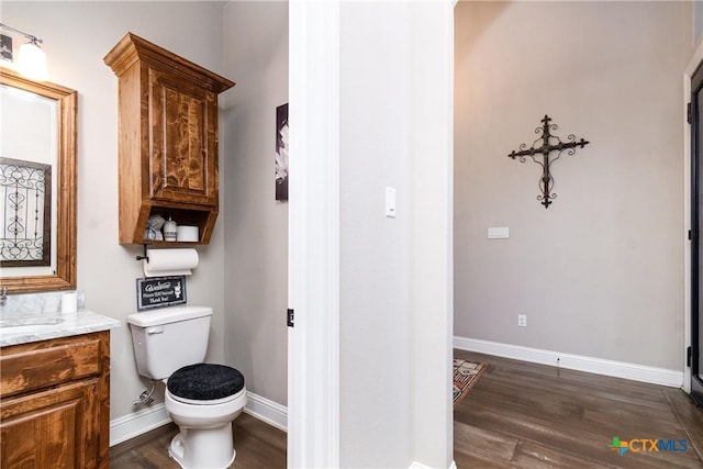 bathroom featuring wood-type flooring, vanity, and toilet