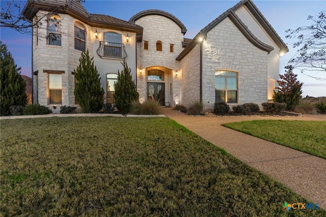 french country home with french doors and a lawn