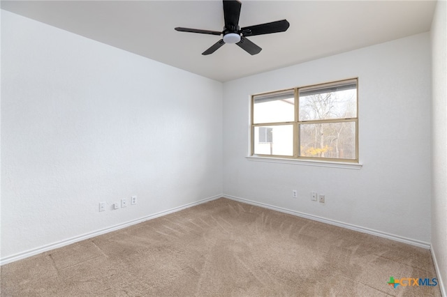 carpeted spare room featuring ceiling fan