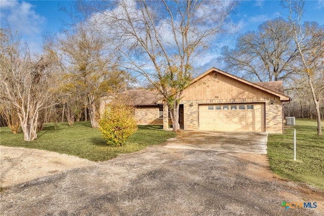 view of front of home featuring central AC unit, a garage, and a front lawn